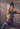 Frau beim Kurzhantel-Training im Fitnessstudio: Sie führt eine Kniebeuge mit ausgestreckten Armen und zwei Kurzhanteln aus.