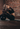 Frau sitzt erschöpft auf einer Gymnastikmatte nach einem Medizinball-Workout.